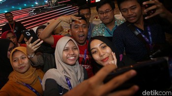 Sejumlah pengunjung melakukan swafoto bersama staf khusus Presiden Gracia Billy Mambrasar yang hadir turut mengisi acara di Telkomsel The Nextdev Summit 2019, Jakarta, Sabtu (7/12/2019).