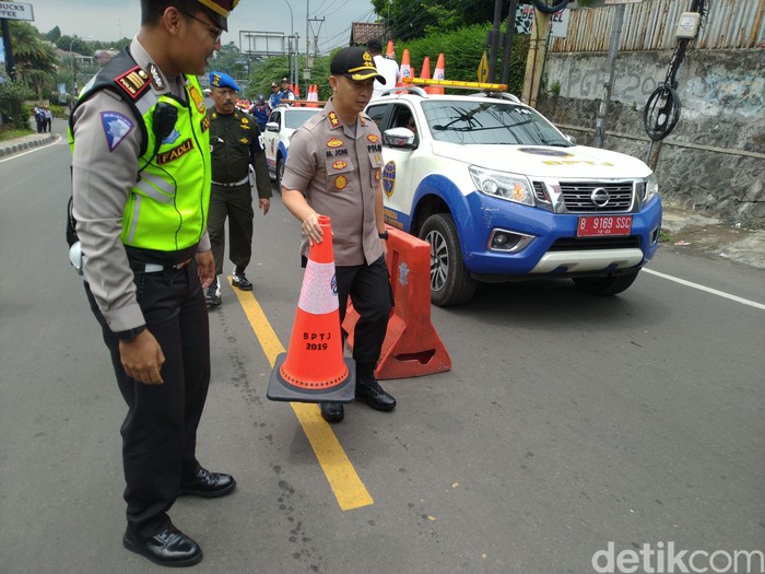 Kapolres Bogor AKBP Muhammad Joni menaruh traffic cone pertama sebagai tanda uji coba sistem 2-1 mulai diberlakukan.
