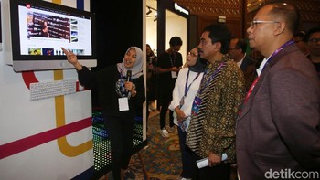 Mereka tampak mendengarkan penjelasan di salah satu booth yang hadir di dalam event The NextDev Summit 2019.