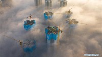 Gedung-gedung ini tampak masih dalam proses konstruksi sehingga membuat penampakannya seperti tengah membangun sebuah negeri di atas awan. Foto: Dok. Xinhua/Liu Xu