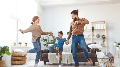 happy family mother father and child daughter dancing at home