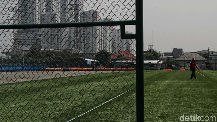 Pekerja menyelesaikan pembangunan lapangan sepakbola di kawasan Muara Angke, Jakarta Utara, Senin (9/12). Lapangan ini menggunakan rumput sintesis.