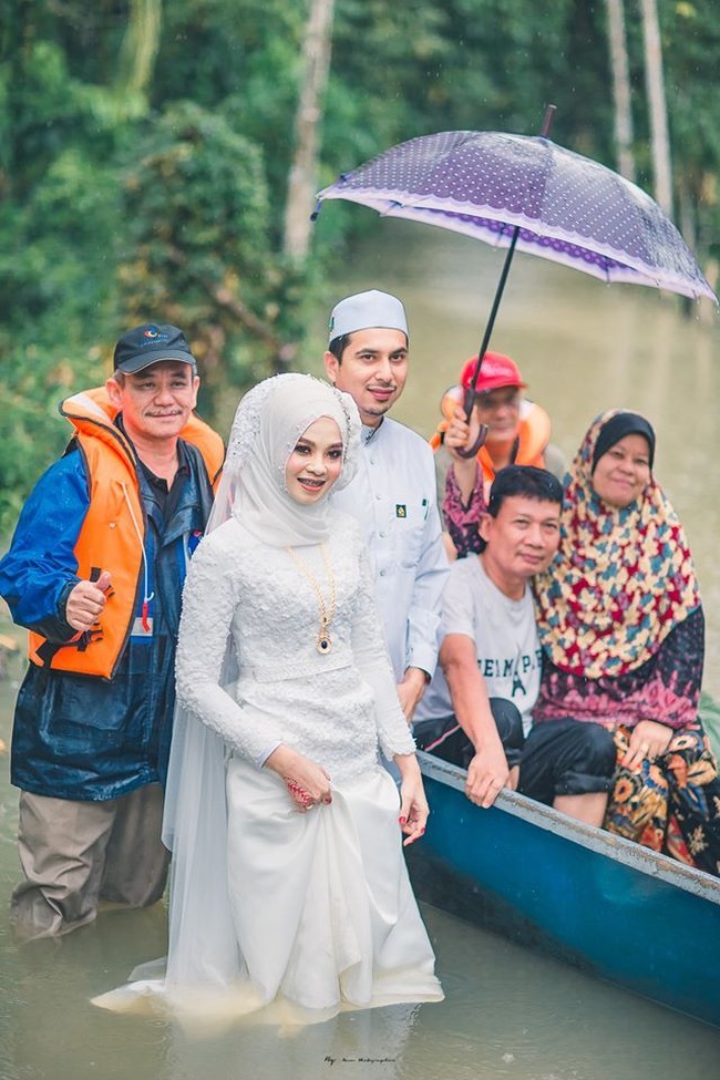 Mereka siap berjalan melalui air banjir dan perahu dayung untuk menyambut tamu, sepupu dan teman yang mereka undang,” tulis fotografer pernikahan mereka. Foto: Facebook Meen Photographer