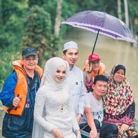 Mereka siap berjalan melalui air banjir dan perahu dayung untuk menyambut tamu, sepupu dan teman yang mereka undang,” tulis fotografer pernikahan mereka. Foto: Facebook Meen Photographer