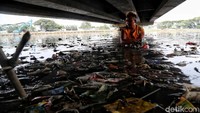 Petugas UPK Badan Air Dinas Lingkungan Hidup saat membersihkan sampah di kawasan Penjaringan, Jakarta Utara.