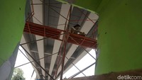 Seorang pekerja nampak sibuk menghias mural yang berada di kolong flyover Pesing agar semakin cantik dan indah dipandang mata.