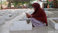 Para keturunan korban mendoakan leluhur di depan makam.