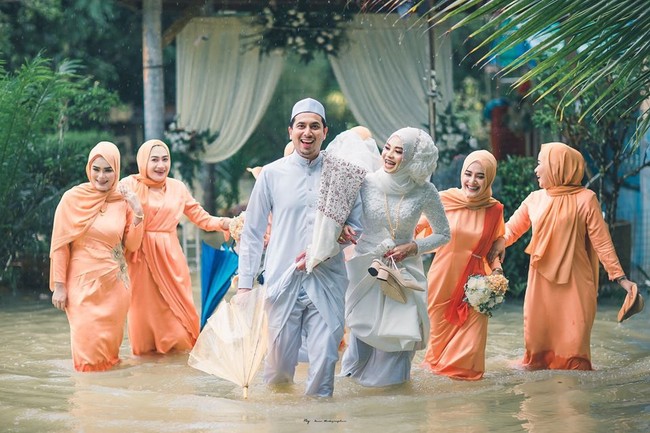 Foto-foto pernikahan mereka di tengah banjir dibagikan oleh Meen Photographer di Facabook dan jadi viral. Bersama para keluarga dan sahabat, pasangan ini pun terlihat sumringah. Foto: Facebook Meen Photographer