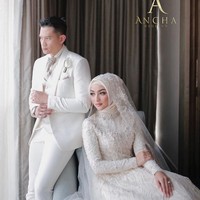 Sementara itu, Rezky Aditya juga tak kalah modis. Senada dengan warna gaun istrinya, sang aktor mengandalkan setelan putih. Sebagai pemanis, sekuntum bunga Calla Lily disematkan di dekat kantong sebagai pengganti korsase yang elegan. (Foto: Instagram/@anchawedding)