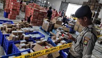 Polisi nampak bersiaga dan memasang garis polisi di gudang tersebut.