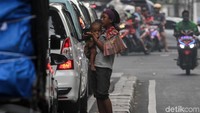 Ia menghampiri mobil-mobil yang tengah menunggu lampu merah di Jalan Cideng Barat.