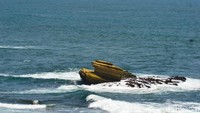 Ikon batu karang di tengah laut yang selama ini menjadi asal muasal nama Batu Hiu, kini bentuknya tak lagi mirip sirip hiu. Akibat dikikis ombak (Faizal Amiruddin/detikcom)