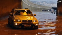 Mobil BMW ini sukses menerobos banjir. AP Photo/Bilal Hussein.
