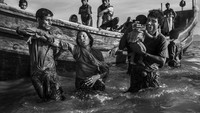 Beberapa pengungsi Rohingya termasuk anak-anak turun dari sebuah kapal ketika tiba di Shah Porir Dwip, dekat Coxs Bazar, Bangladesh, pada 1 Oktober 2017. Kevin Frayer/Getty Images.