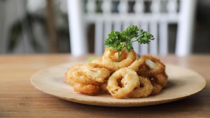 Caramari , Appetizer Crispy fried squid ring with tartar sauce on wood background traditional italian food