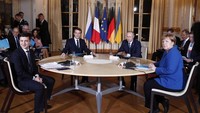 Keduanya duduk bersama dengan disaksikan Presiden Prancis Emmanuel Macron dan Kanselir Jerman Angela Merkel. Ian Langsdon/Pool via AP.