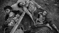 Minara Hassan dan suaminya Ekramul terbaring kelelahan di sisi Sungai Naf di Bangladesh, setelah melarikan diri dari rumah mereka di Maungdaw, Myanmar, pada 2 Oktober 2017. Kevin Frayer/Getty Images.