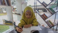 Seorang anak tengah memanfaatkan ruang baca untuk menambah ilmu.
