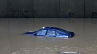 Sebuah mobil berenang di terowongan yang terendam banjir di Beirut, Libanon, Senin (9/12). AP Photo/Bilal Hussein.