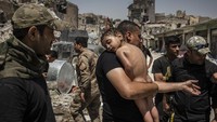 Seorang bocah tampak diangkut oleh para pasukan khusus Irak dari Kota Tua terakhir yang dikuasai ISIS pada 12 Juli 2017 lalu. Para prajurit curiga bahwa bocah tersebut digunakan sebagai perisai manusia bagi para militan ISIS untuk melarikan diri.