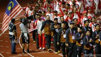 Kontingen Malaysia melakukan parade dengan mengibarkan bendera negaranya.