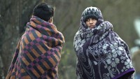 Dua orang imigran nampak membalut dirinya dengan selimut guna menghangatkan tubuh di tengah cuaca dingin Bosnia beberapa waktu lalu. Kemal Softic/AP Photo.