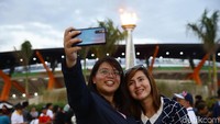 Beberapa warga swafoto dengan latar belakang Stadion Clark.