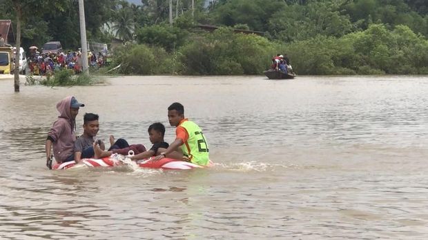 Warga yang membawa motornya dikenai biaya Rp 15 ribu saat naik perahu.