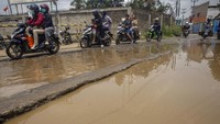 Sejumlah pengendara melintasi Jalan Raya Tapos, Cibinong, Bogor, yang rusak dan tergenang air, Rabu (11/12/2019).