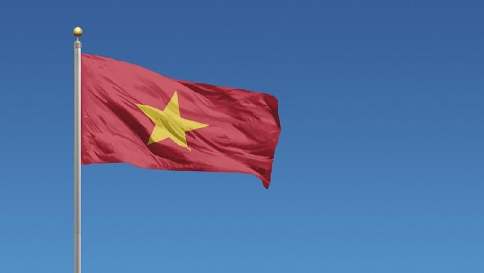Flag of Vietnam in front of a clear blue sky