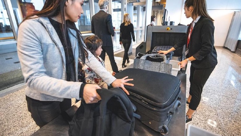 Ilustrasi traveler di bandara Mother picking backpack from security counter while standing by daughters. Family is with luggage at airport terminal. They are going on vacation.