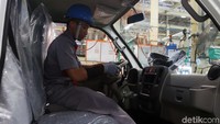 Pekerja tengah mengecek bagian kemudi Isuzu Traga.