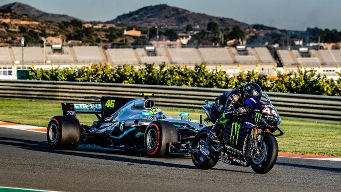 Dua legenda balap, Valentino Rossi dan Lewis Hamilton, bertukar tunggangan. Momen itu terjadi di Sirkuit Circuit Ricardo Tormo. Berikut potretnya.