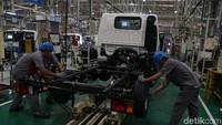 Para pekerja tengah memasang ban Isuzu Traga.