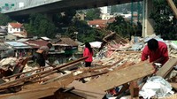 Dengan menggunakan alat sederhana mereka menyisir setiap bangunan yang kini telah rata dengan tanah.