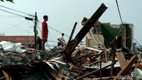 Nampak beberapa warga tengah sibuk mencari puing-puing bangunan yang masih bisa digunakan kembali.