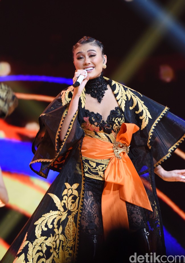 Anne Avantie juga membuatkan jubah bermotif floral dalam nuansa keemasan. Luaran tersebut tampak dramatis dengan lengan bertumpuk dan ekor panjang. (Foto: Noel/detikFoto)