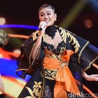 Anne Avantie juga membuatkan jubah bermotif floral dalam nuansa keemasan. Luaran tersebut tampak dramatis dengan lengan bertumpuk dan ekor panjang. (Foto: Noel/detikFoto)