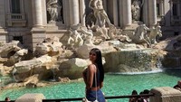 Cantik senyumnya di air mancur yang ikonik di Italia, Trevi Fountain. (tamaryngreen/Instagram)