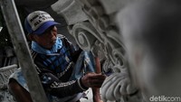 Pekerja tampak sangat teliti saat mengukir atau membentuk patung.