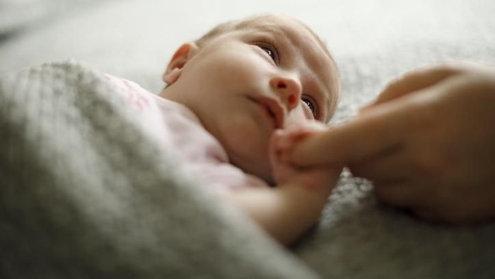 Newborn baby holding mothers hand