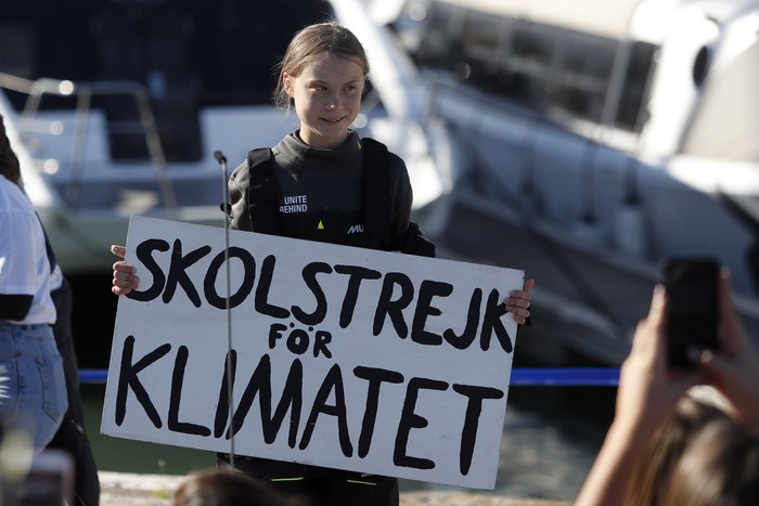 Climate activist Greta Thunberg holds a sign reading School strike for the climate after arriving in Lisbon, aboard the sailboat La Vagabonde, Tuesday, Dec 3, 2019. Thunberg has arrived by catamaran in the port of Lisbon after a three-week voyage across the Atlantic Ocean from the United States. The Swedish teen sailed to the Portuguese capital before heading to neighboring Spain to attend the U.N. Climate Change Conference taking place in Madrid. (AP Photo/Armando Franca)