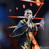 Dengan bahu yang terbuka, atasan tersebut sukses mempertegas aura seksi Agnez Mo. Untuk menyempurnakan gayanya, ia memakai statement necklace hitam berikut boot kulit setinggi lutut. (Foto: Noel/detikFoto)