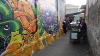 Lihat mural yang dibuat seniman asal China di lapangan tenis rumah warga.  Foto: Tia Agnes
