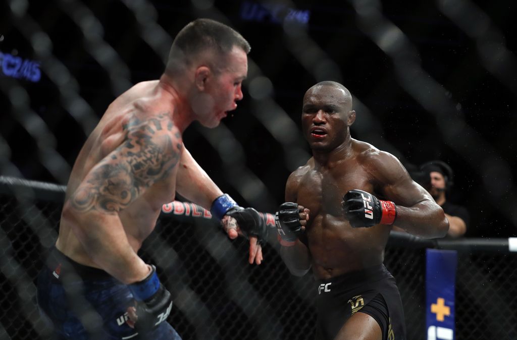 LAS VEGAS, NEVADA - DECEMBER 14:  Colby Covington (L) falls back from a punch by UFC welterweight champion Kamaru Usman in the fifth round of their welterweight title fight during UFC 245 at T-Mobile Arena on December 14, 2019 in Las Vegas, Nevada. Usman retained his title with a fifth-round TKO.  (Photo by Steve Marcus/Getty Images)