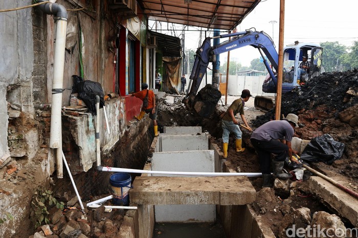 Pekerja membuat saluran drainase di Jalan Pemuda, Rawamangun, Jakarta Timur, Senin (16/12/2019). Proyek tersebut merupakan salah satu langkah perbaikan sistem drainase untuk mengantisipasi banjir saat hujan turun.