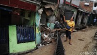 Rumah yang pagarnya ambruk posisi fondasinya berada di atas saluran air, sehingga tak kuat menahan beban rumah.