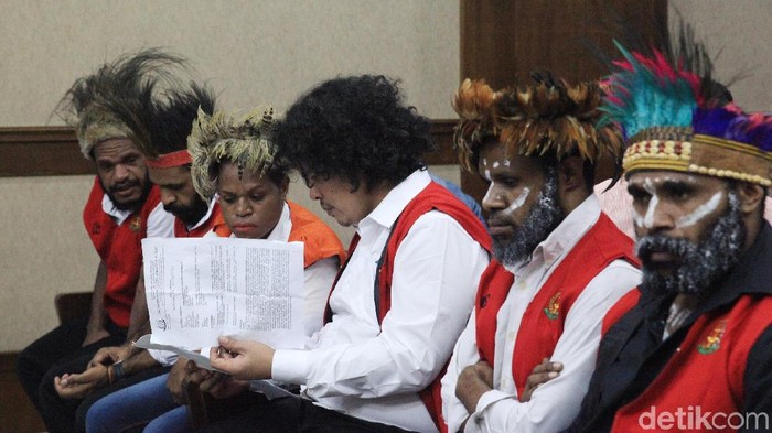 Lima tersangka pengibar bendera bintang kejora memakai topi adat khas Papua bernama kari-kari saat menjalani sidang perdana.