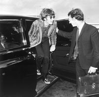 John Lennon keluar dari mobil saat tiba di bandara Liverpool pada