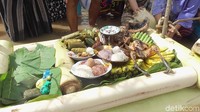 Sebelum mandi bersama dimulai, warga terlebih dahulu melarungkan aneka macam makanan, disimpan di atas perahu yang  terbuat dari batang pisang (Abdy Febriady/detikcom)